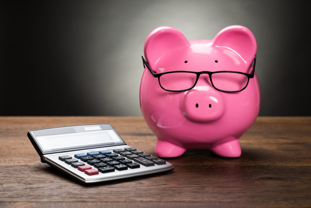 Piggy bank and calculator used for sticking to a budget