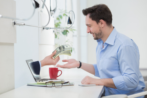 Using your tax refund wisely-man being handed a stack of money.