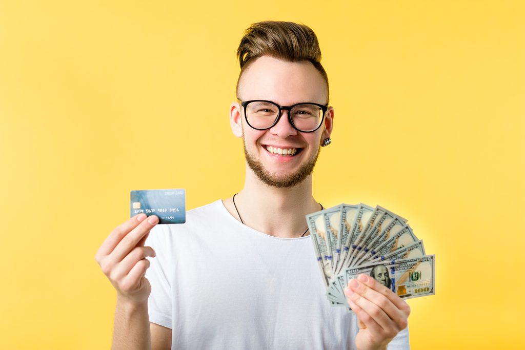 A hip young man weighs his options: credit and debit and cash