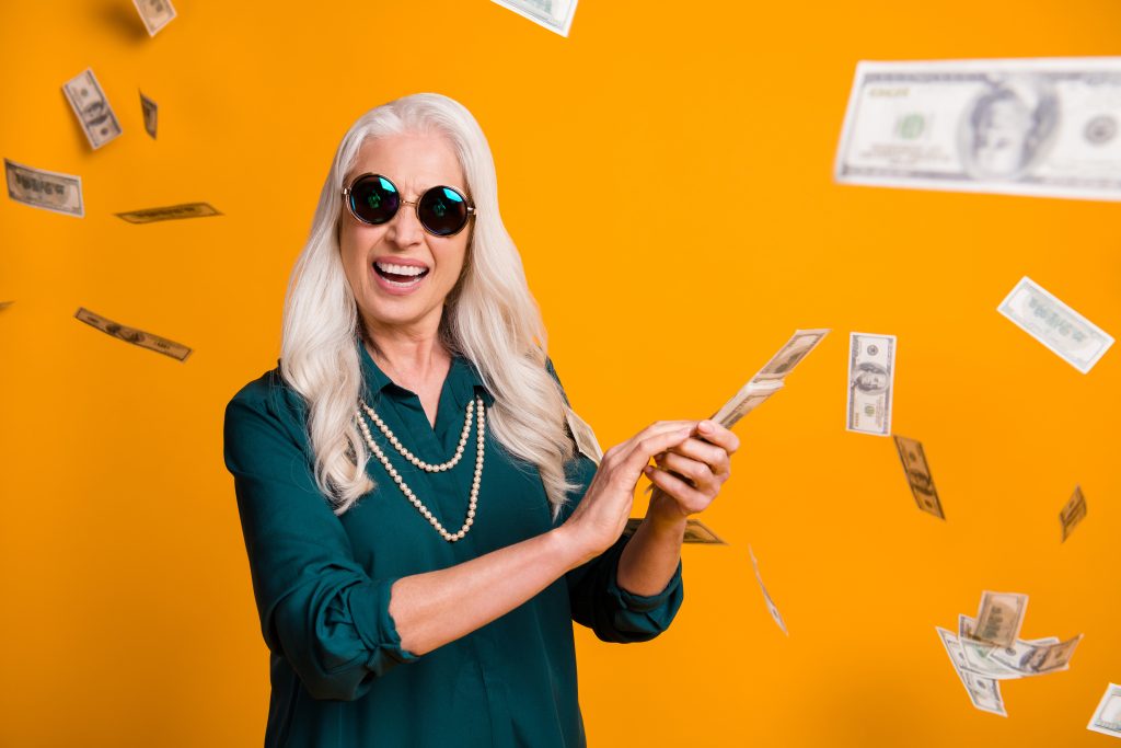 Senior woman doing retirement planning and "making it rain" thanks to a timely Roth IRA conversion.