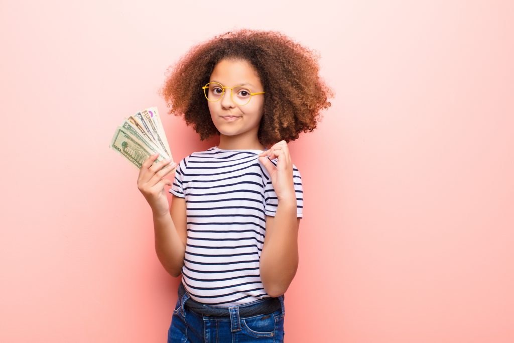 A young girl learning about money and ragging a bit at how much she has saved.