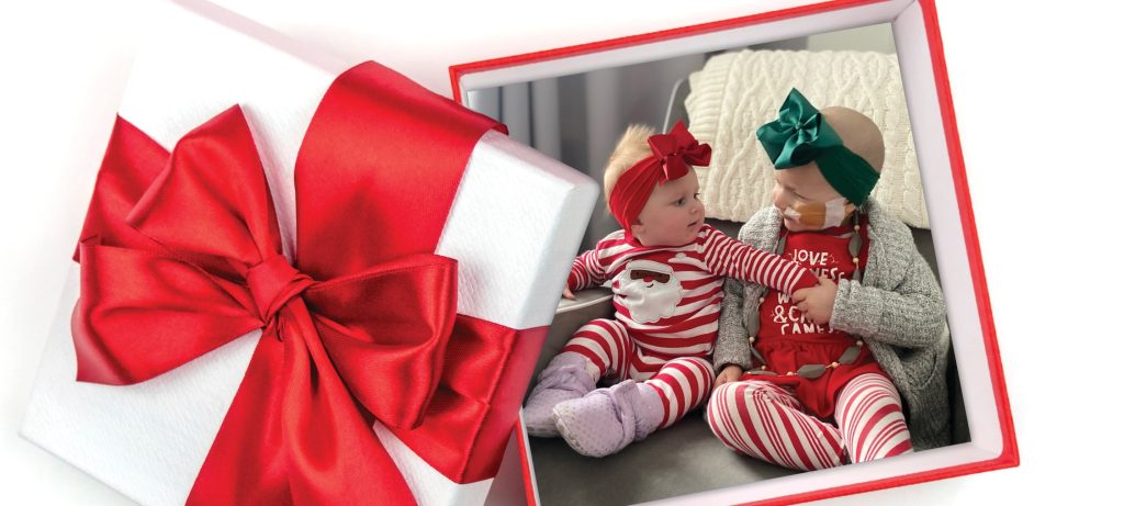 Adopt-A-Family logo featuring a gift box with two children dressed in festive attire, spending the holiday together.