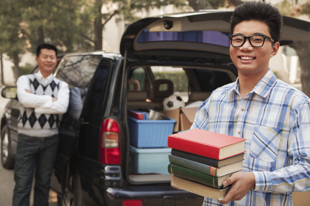 Student loading up books, clothes, and other items purchased with college savings as they make their way to freshmen year