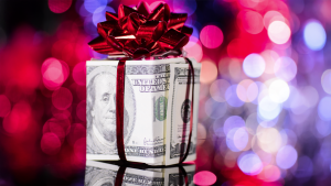 Image of a holiday box with ribbon constructed from a dollar bill as part of a charitable tax deduction