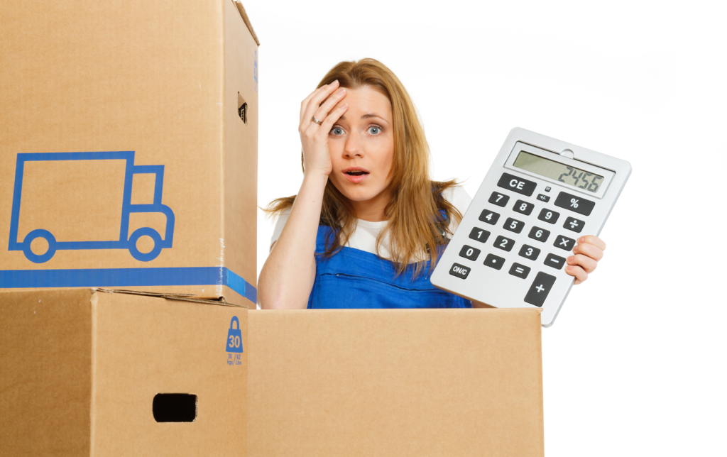 A woman panicking over moving costs. She holds a giant calculator and is hiding behind moving boxes.